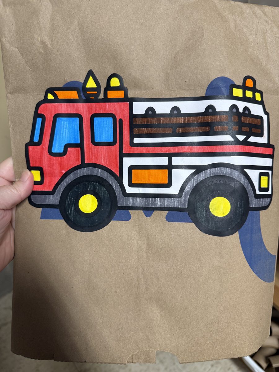 Paper bag firefighter jacket craft: a colored red fire truck on a brown paper bag
